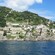 Coastal waters bordering hills featuring buildings and lush greenery